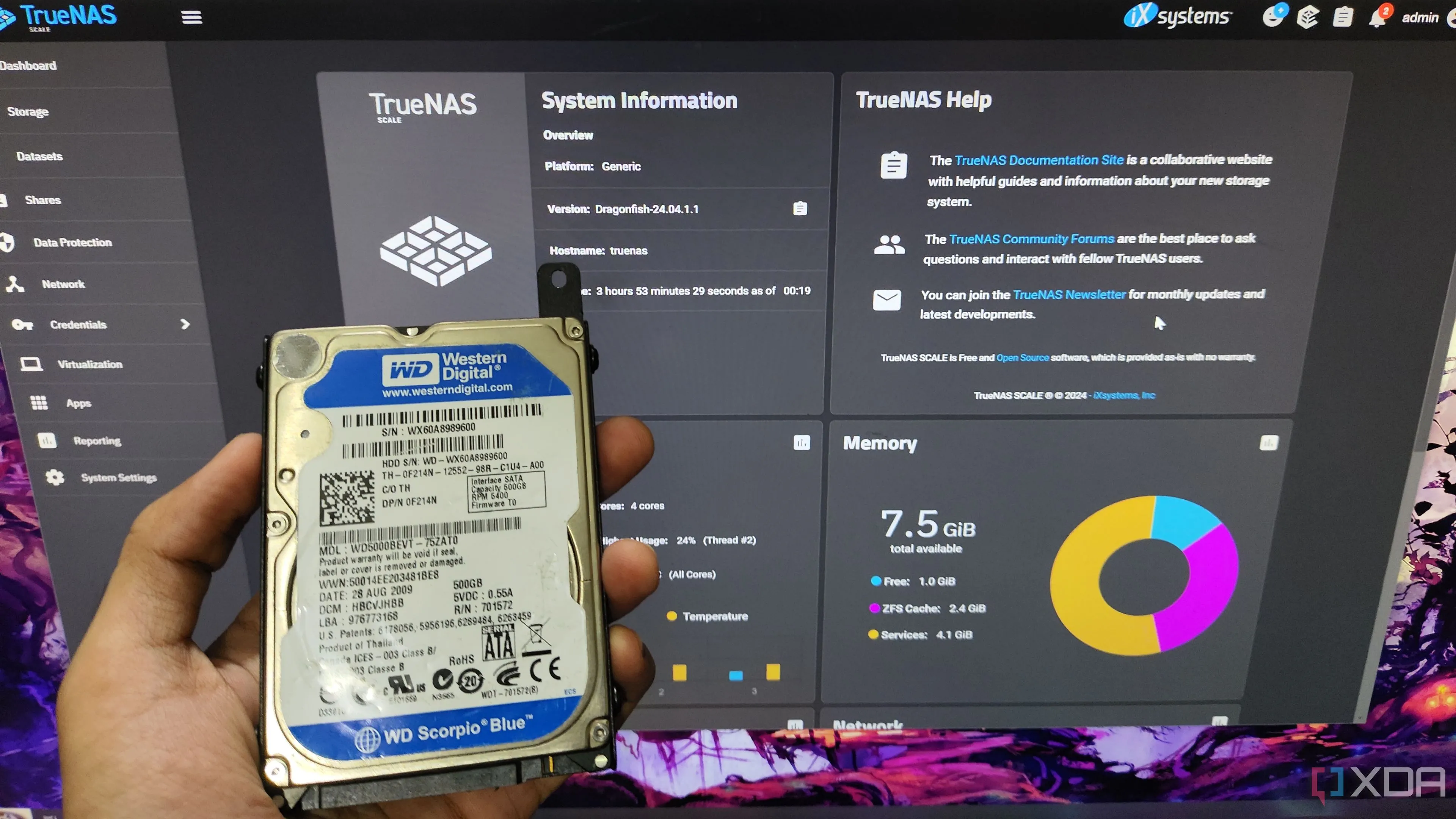 Một người cầm ổ cứng HDD trước màn hình hiển thị giao diện TrueNAS Scale, minh họa cho việc sử dụng HDD trong NAS