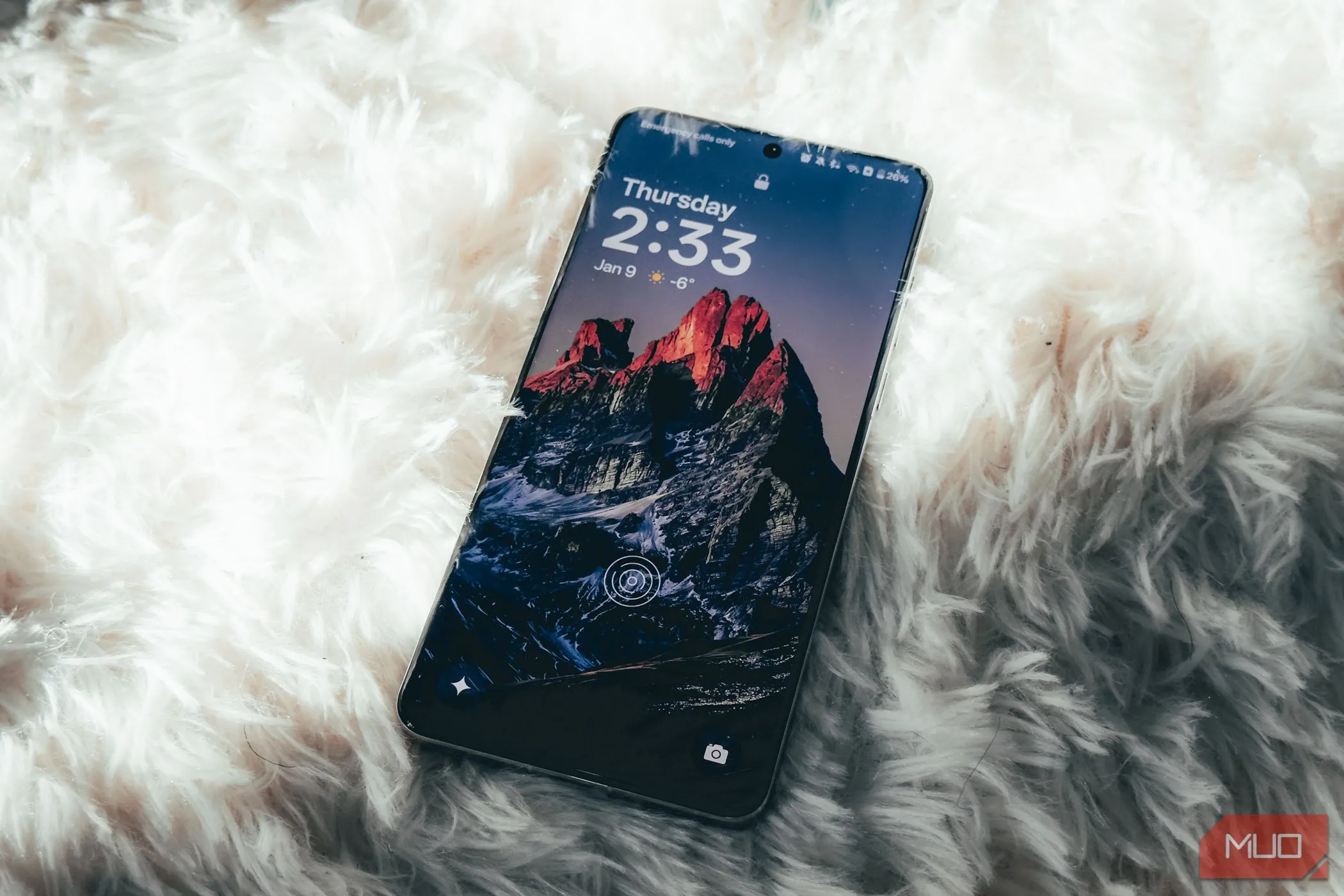 Điện thoại OnePlus 13 với màn hình đang bật, đặt nghiêng trên bề mặt thảm, làm nổi bật giao diện OxygenOS.