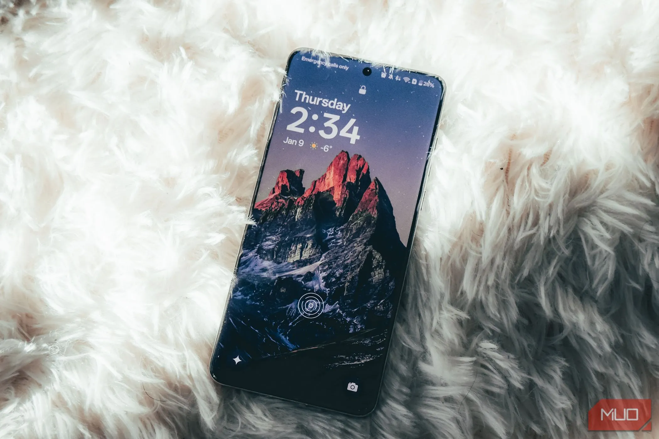 Điện thoại OnePlus 13 với màn hình rực rỡ đang hiển thị nội dung, đặt trên bề mặt màu trắng.