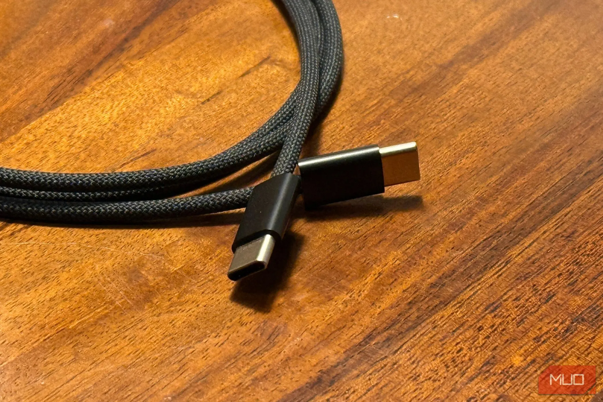 Hai đầu cáp USB-C sang USB-C đặt trên bàn gỗ