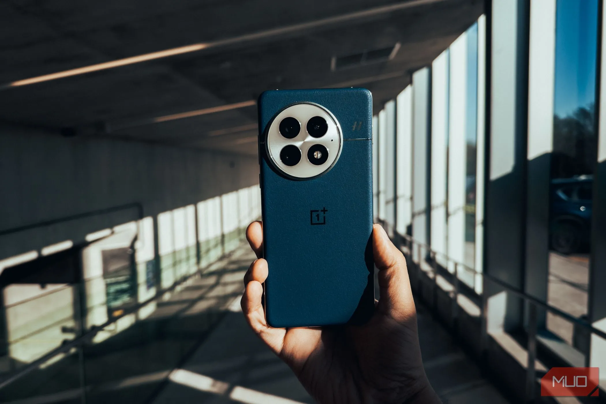 Mặt lưng của điện thoại OnePlus 13 màu xanh Midnight Ocean đặt trên nền phong cảnh đô thị, thể hiện sự sang trọng và hiện đại.