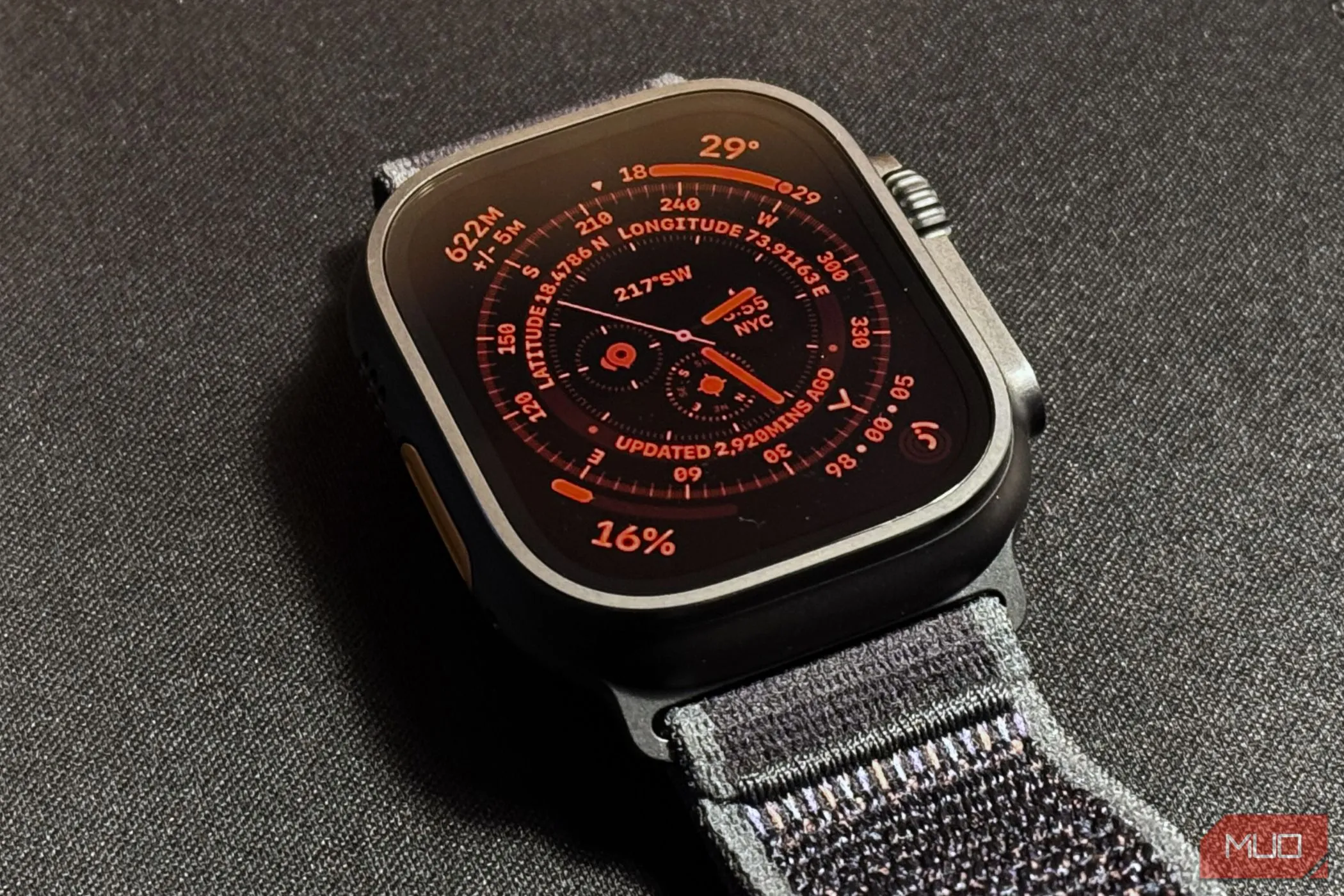Apple Watch Ultra 2 với chế độ ban đêm hoạt động trên mặt đồng hồ đặt trên thảm đen