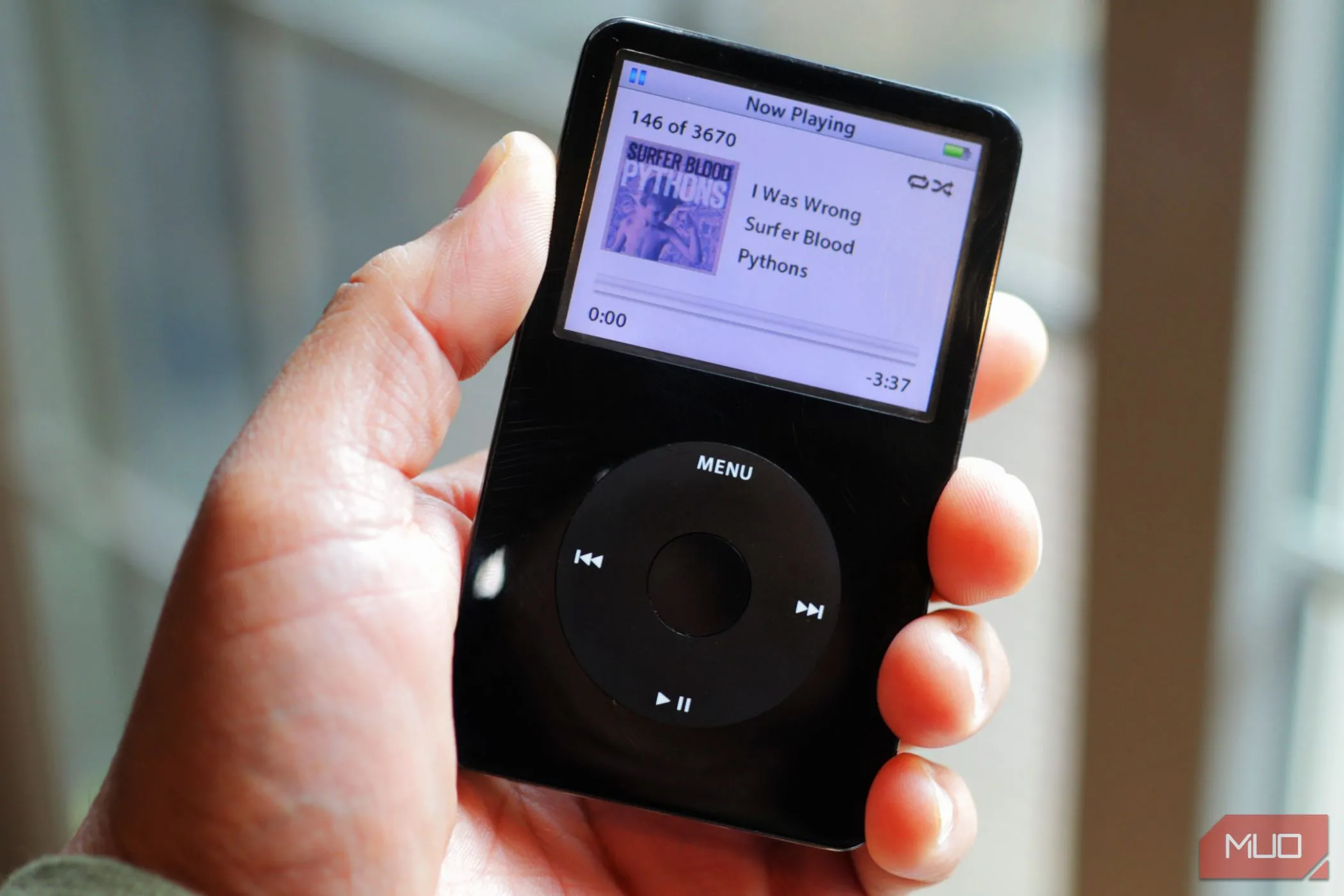 Chiếc iPod Classic màu đen trong tay, gợi nhớ kỷ nguyên máy nghe nhạc MP3 trước khi smartphone thống trị.