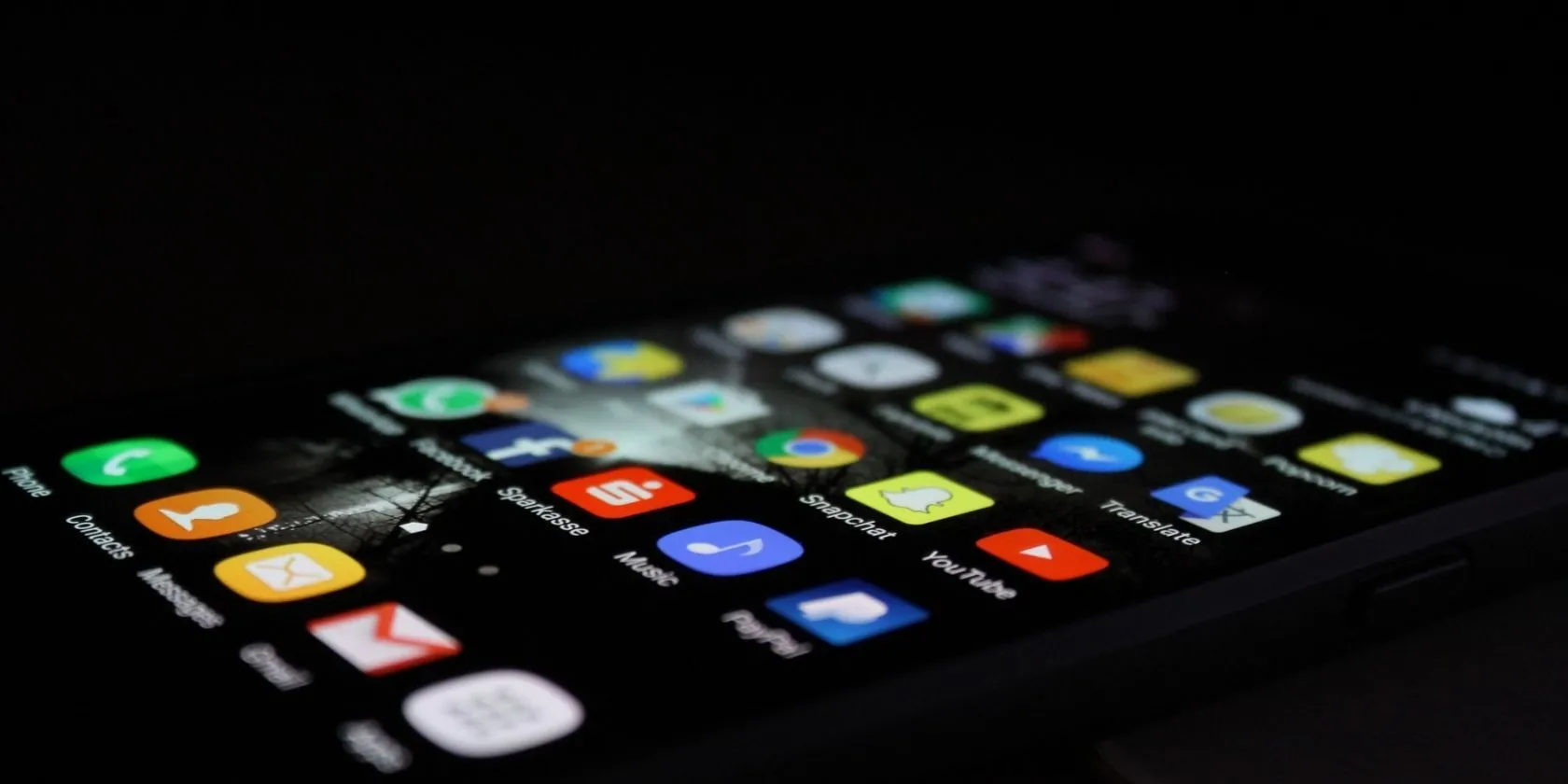 Điện thoại iPhone màu đen hiển thị các ứng dụng trên màn hình chính, minh họa cho việc cài đặt ứng dụng từ nguồn không chính thức