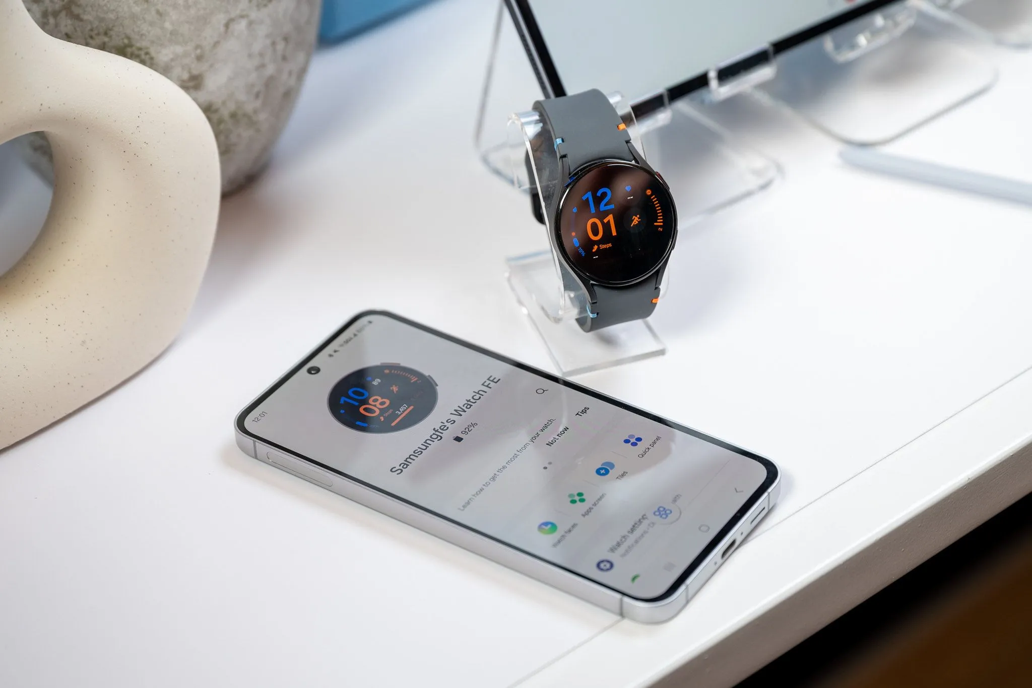 Điện thoại Samsung Galaxy S24 FE đang sạc pin cho đồng hồ Galaxy Watch thông qua cáp USB-C, minh họa tính năng sạc ngược