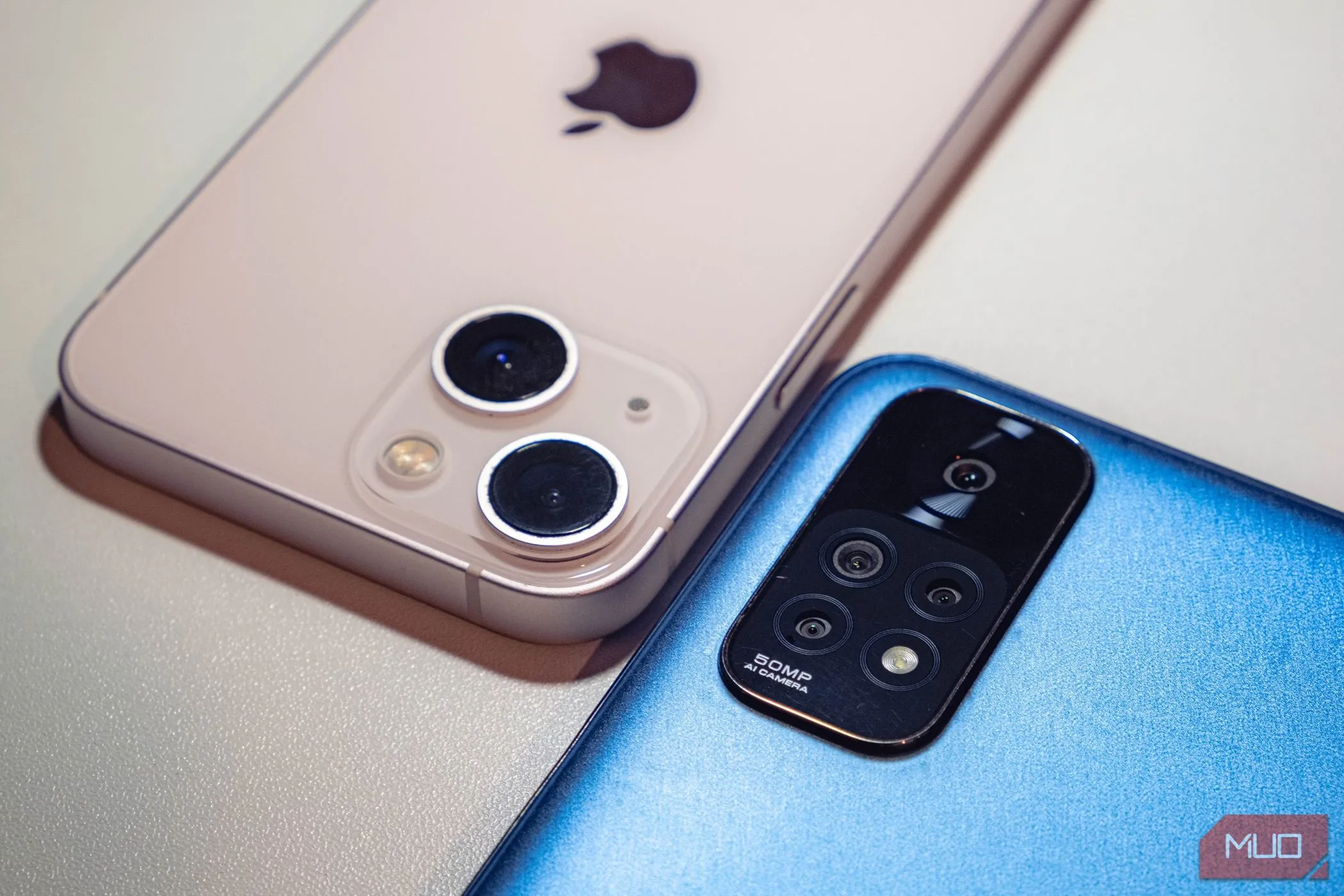 Hai chiếc smartphone tầm trung màu xanh và hồng đặt úp, biểu tượng cho sự đa dạng và chất lượng của dòng điện thoại giá phải chăng