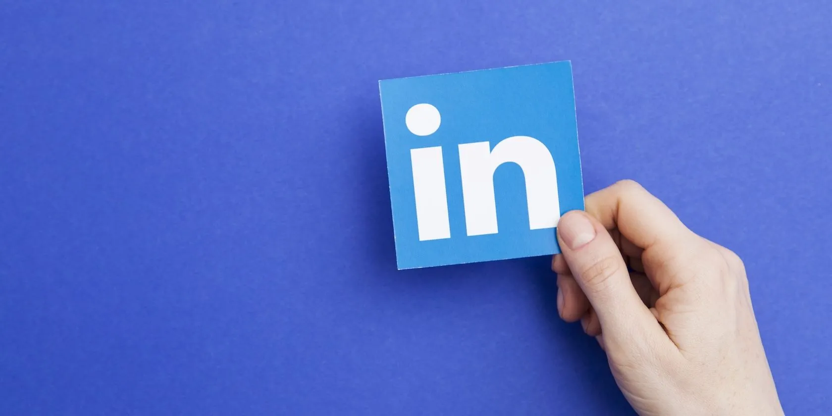 Logo LinkedIn được cầm trên tay, biểu tượng của mạng xã hội chuyên nghiệp thu thập và sử dụng dữ liệu người dùng để đào tạo AI