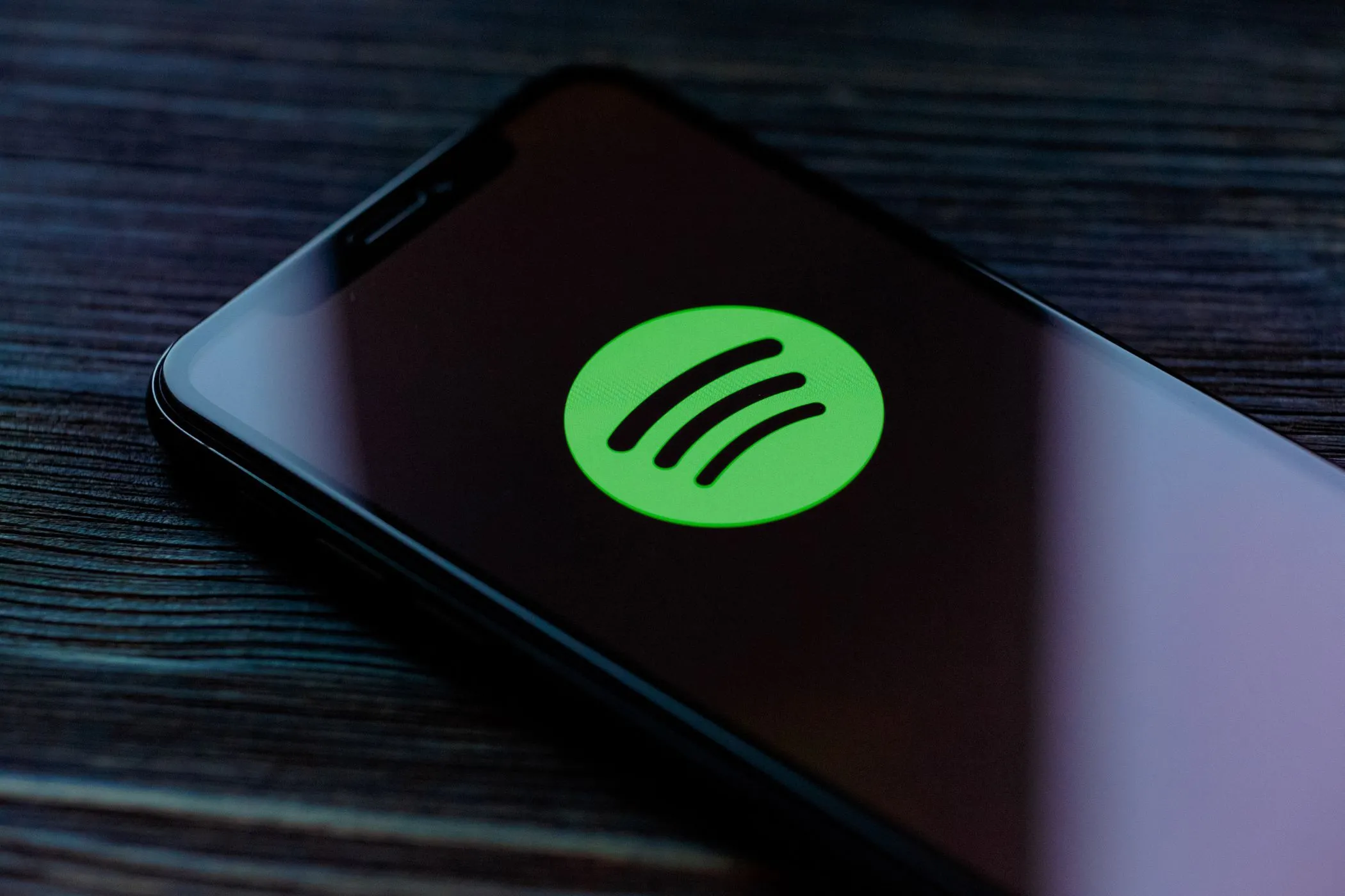 Logo Spotify trên điện thoại thông minh, minh họa việc ứng dụng nghe nhạc theo dõi thói quen và dữ liệu chuyển động