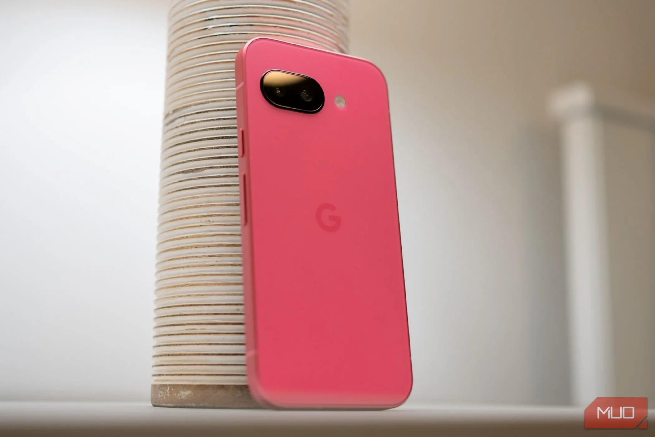 Mặt lưng của điện thoại Google Pixel 9a màu đen, đặt trên mặt bàn, thể hiện thiết kế sang trọng và hiện đại.