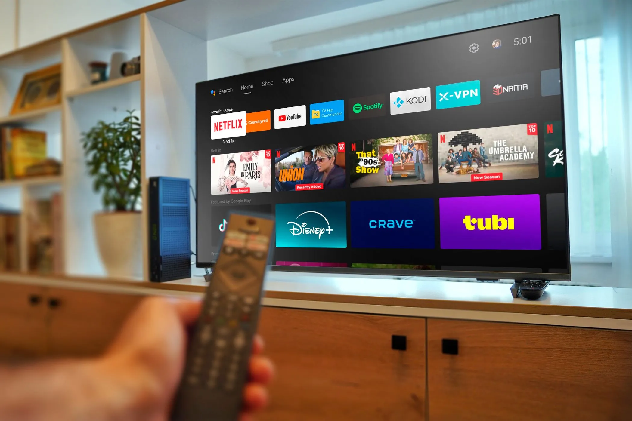 Một chiếc Android TV với tay cầm điều khiển từ xa, thể hiện sự tương tác với các ứng dụng trên TV thông minh