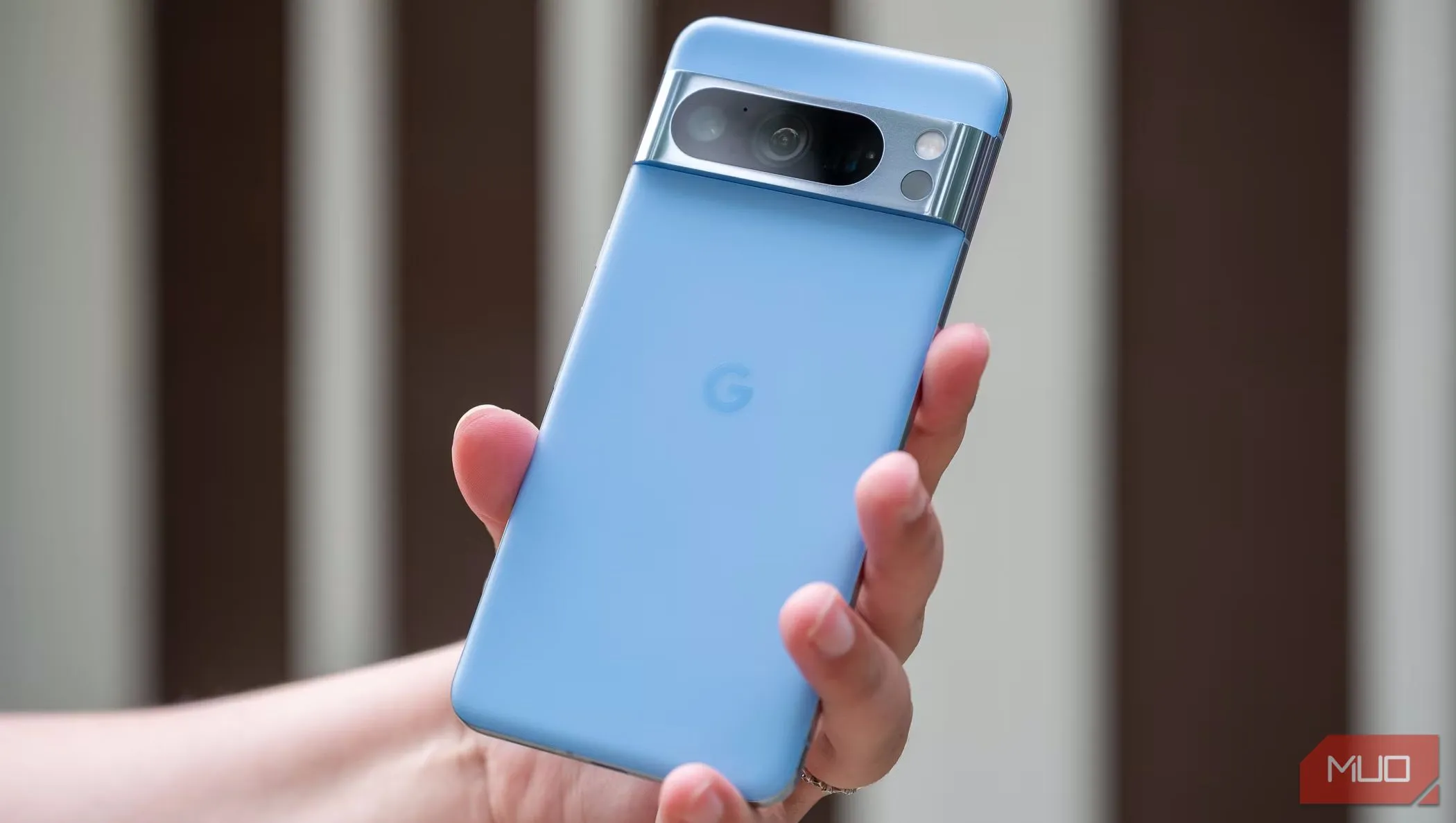 Một người đàn ông cầm điện thoại Pixel 8 Pro và đưa lưng máy ra trước mặt