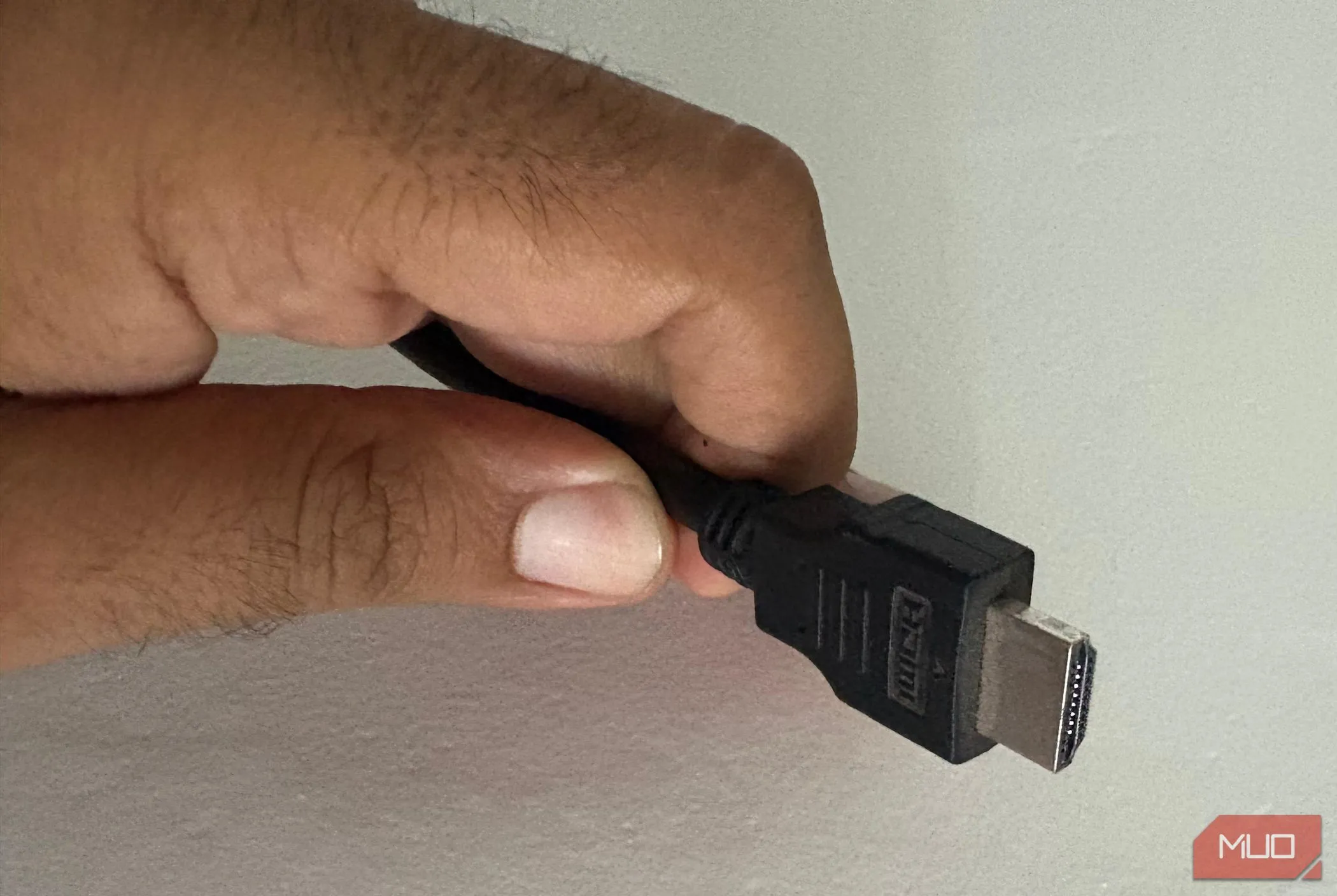 Một người đàn ông đang cầm sợi cáp HDMI tốc độ cao, phụ kiện cần thiết cho trải nghiệm HDR