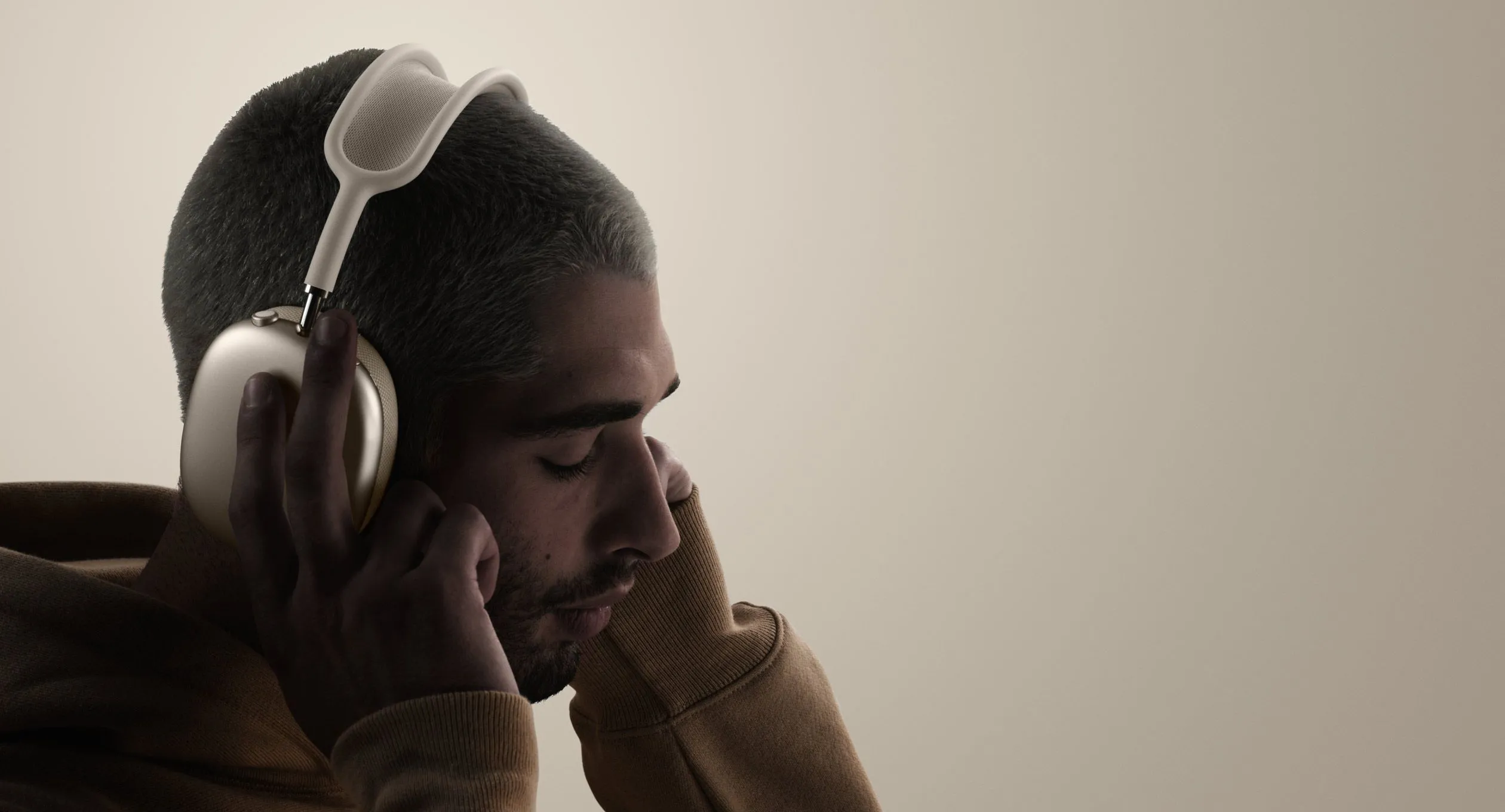 Một người đang đeo tai nghe AirPods Max, cho thấy trọng lượng có thể gây khó chịu khi sử dụng lâu.