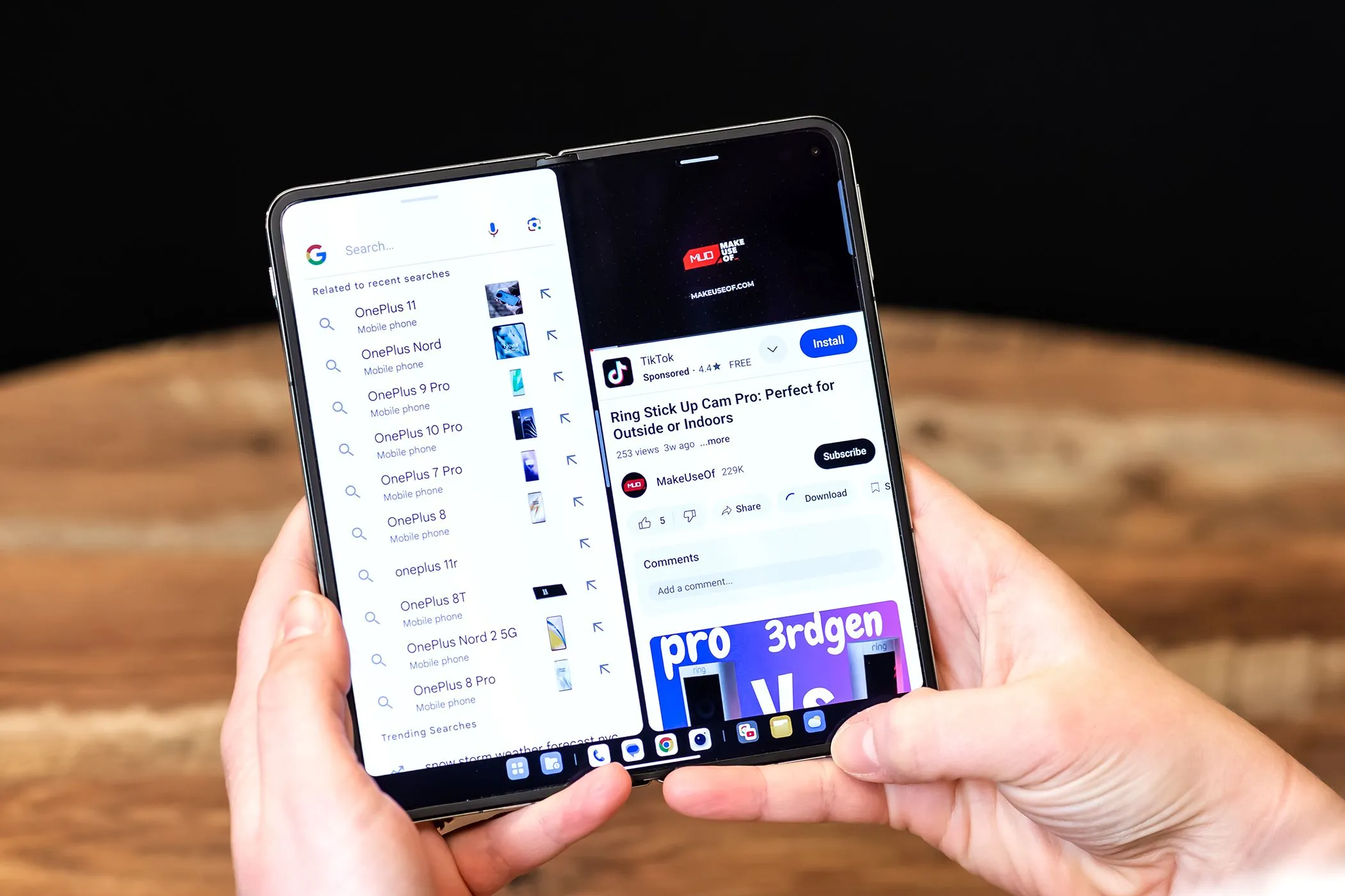 Một người đang sử dụng điện thoại gập OnePlus Open với chế độ chia đôi màn hình, thể hiện sự tối ưu ứng dụng trên màn hình lớn