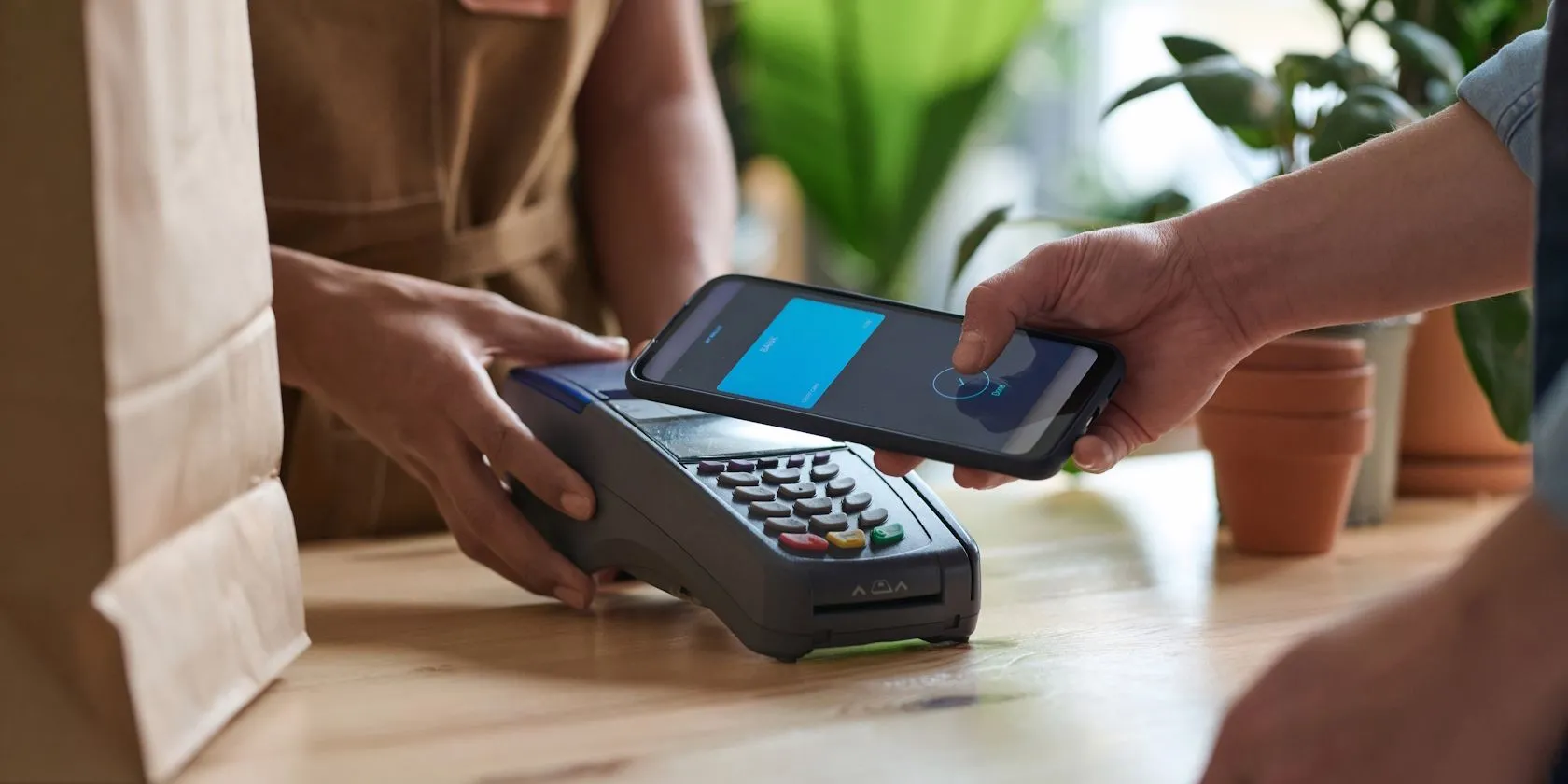 Người đàn ông đang thanh toán không tiếp xúc bằng smartphone tại cửa hàng tạp hóa