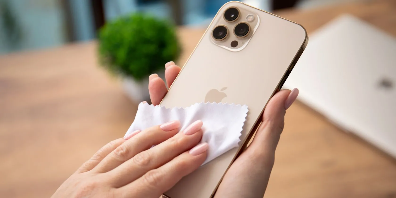 Người phụ nữ đang vệ sinh màn hình iPhone bằng khăn vải microfiber