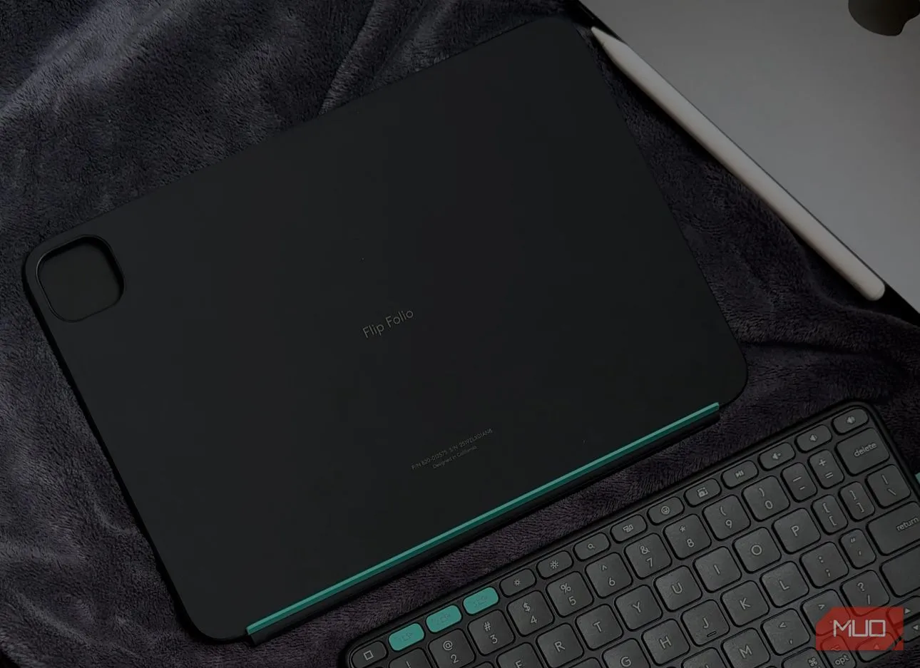 Ốp lưng Logitech Flip Folio được đặt trên chăn cùng với iPad, thể hiện các phím tắt iPadOS