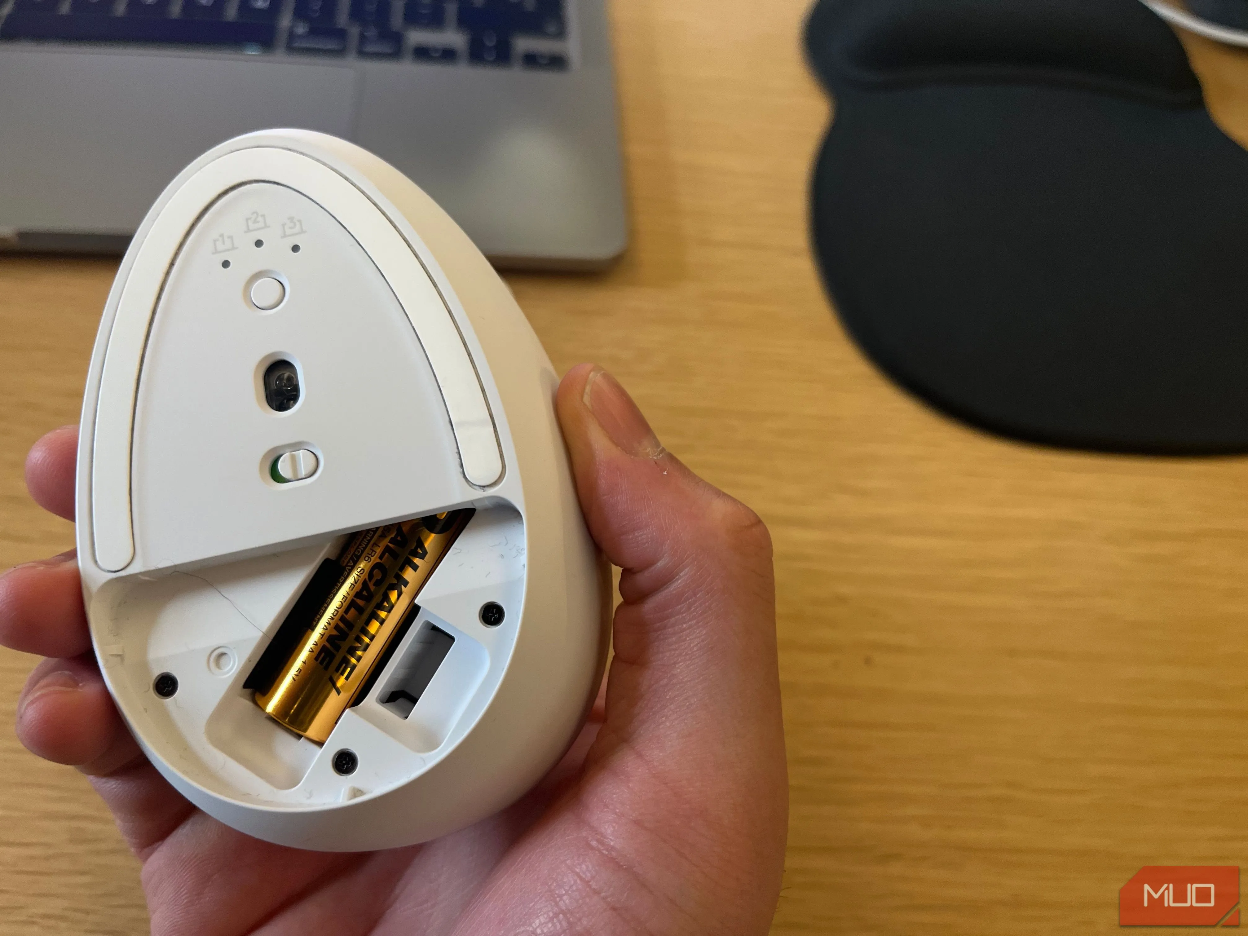 Pin AA có thể thay thế bên trong khoang chứa của chuột không dây, nhấn mạnh về việc cần quản lý năng lượng và thay pin định kỳ.